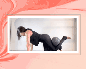 woman performing pilates ball exercise in black activewear set