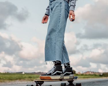 Person wearing slouchy jeans and riding a skateboard.