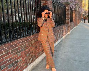 The writer wearing a plaid blazer and matching pants