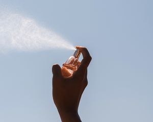 person spraying perfume