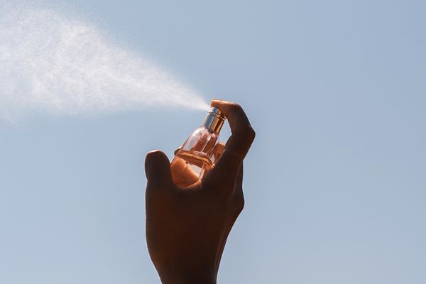 person spraying perfume