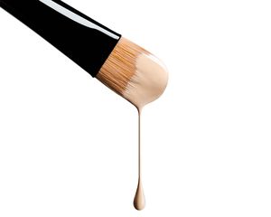 makeup brush dripping with liquid foundation