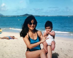 mom holding baby on beach