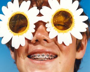 man with braces and flower sunglasses