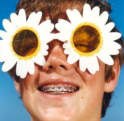 man with braces and flower sunglasses