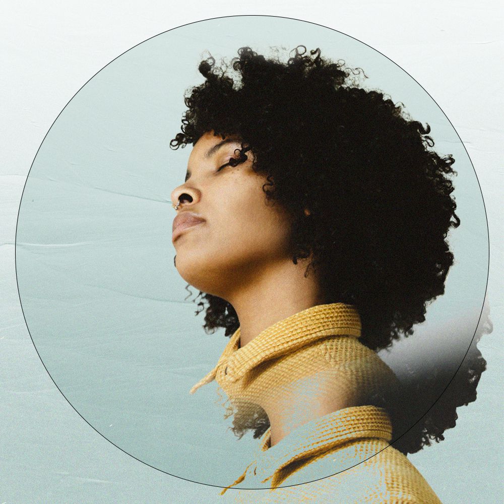 woman with curly hair looking away with eyes closed