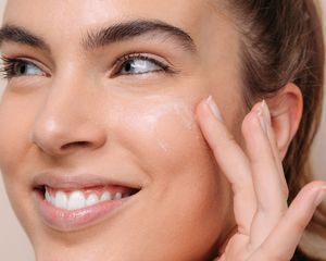woman putting mask on her face