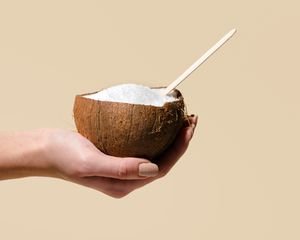 woman holding split coconut