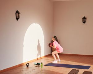 Woman performs wall ball exercises in the afternoon