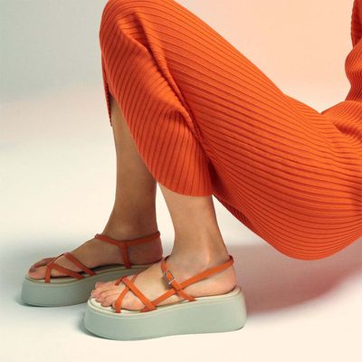 Model wearing an orange knit dress and Vagabond Shoemakers sandals.