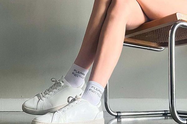Woman wearing Thousand Fell sneakers sitting on a cane chair
