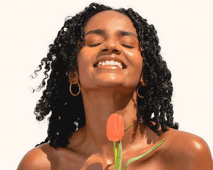 woman holding a tulip and smiling
