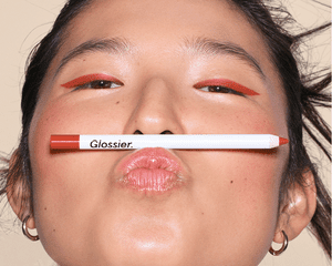 woman wearing Glossier orange eyeliner