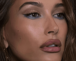 Hailey Bieber wearing blue eyeliner and overlined lips