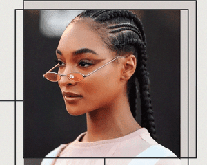 Potrait of BIPOC Woman With Braids and Tiny Sunglasses Wearing Exaggerated Brown Wing Eyeliner made with Eyeshadow